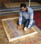 Anas attaching warp threads to the weaving loom