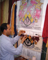 Anas hand-weaving rug knots on the Haslemere Coat of Arms Weavin