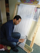 Anas setting the warp tension on the weaving loom